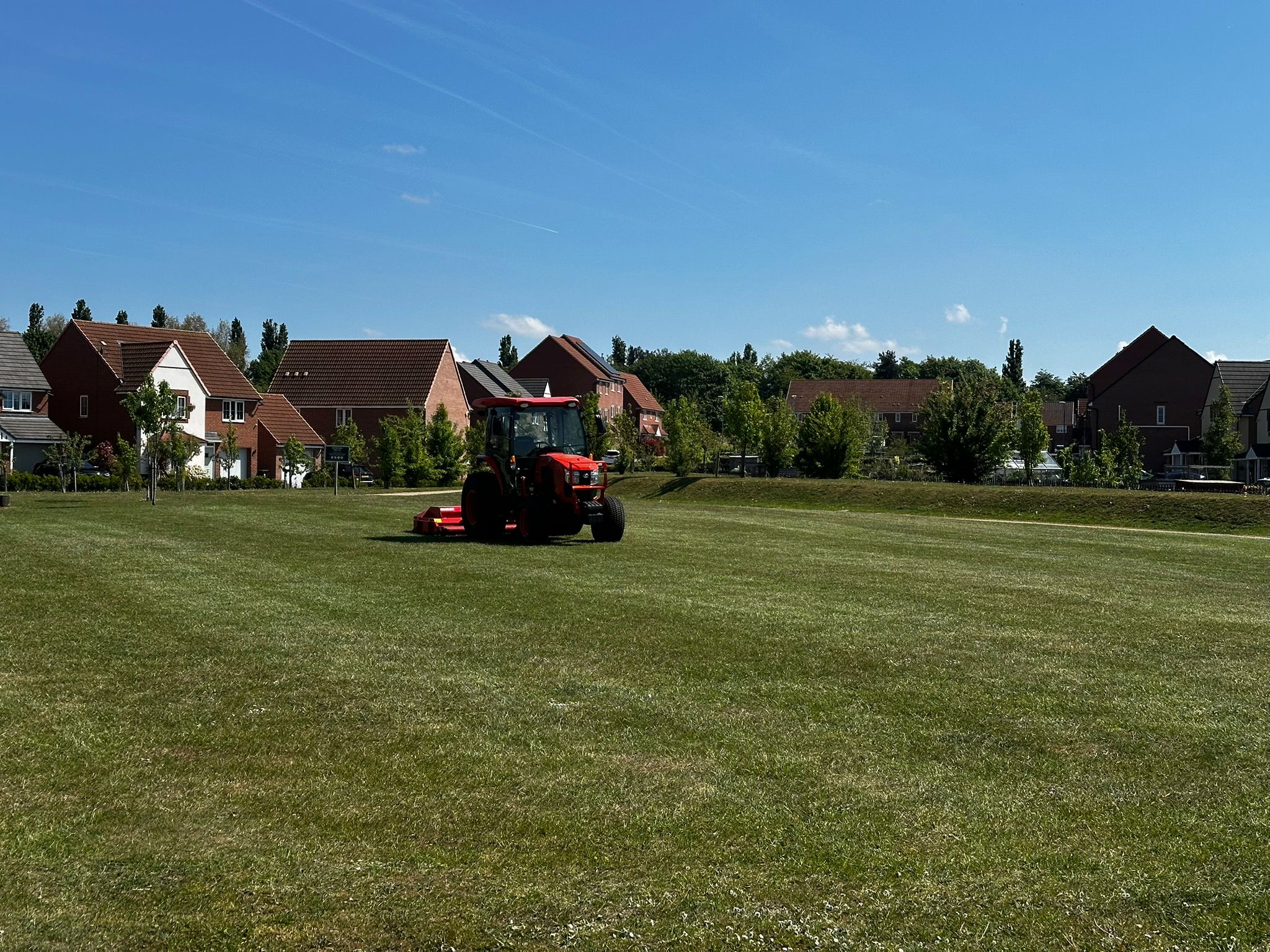 Red mower cutting grass in housing development