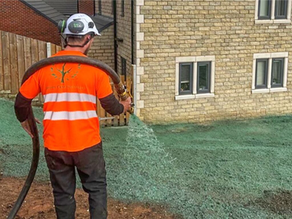 Operative hydroseeding ground beside new homes