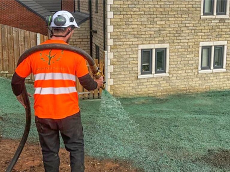 Operative hydroseeding ground beside new homes
